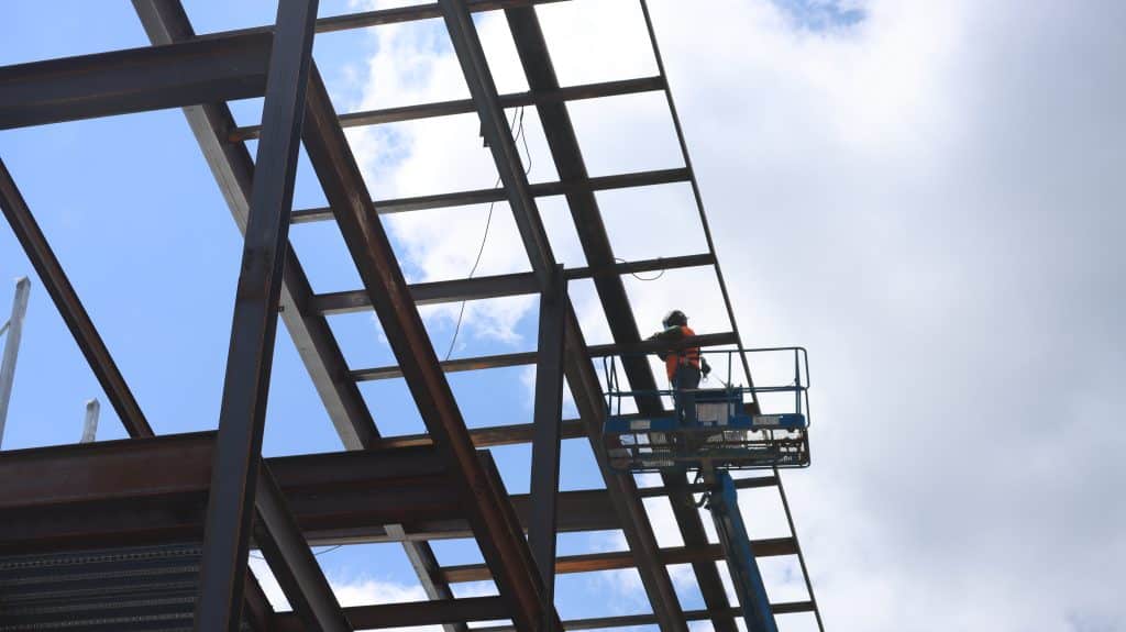 Man welding steel beam on boom lift