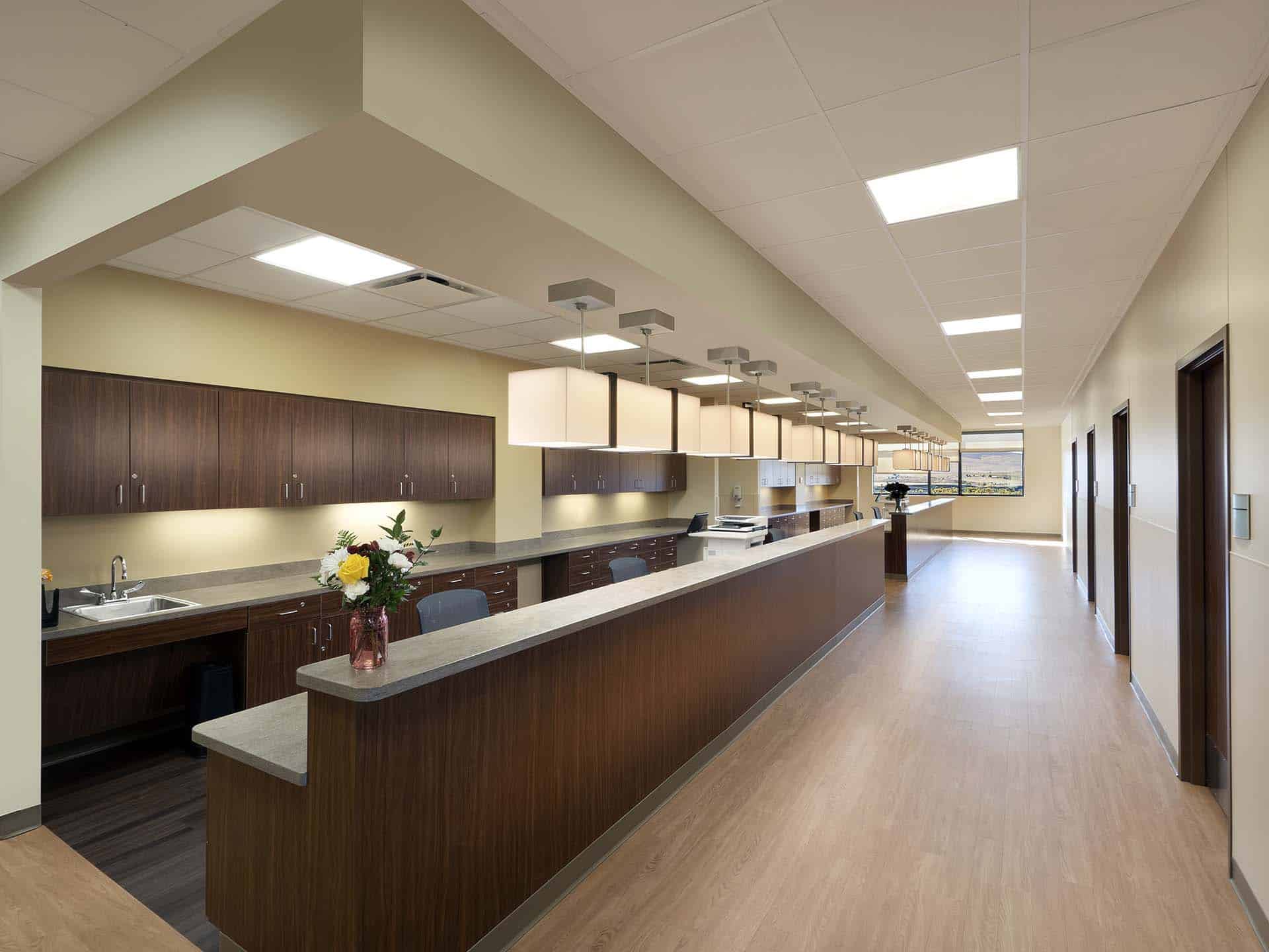 Rows of chairs and cabinets under counters and doors down a hallway