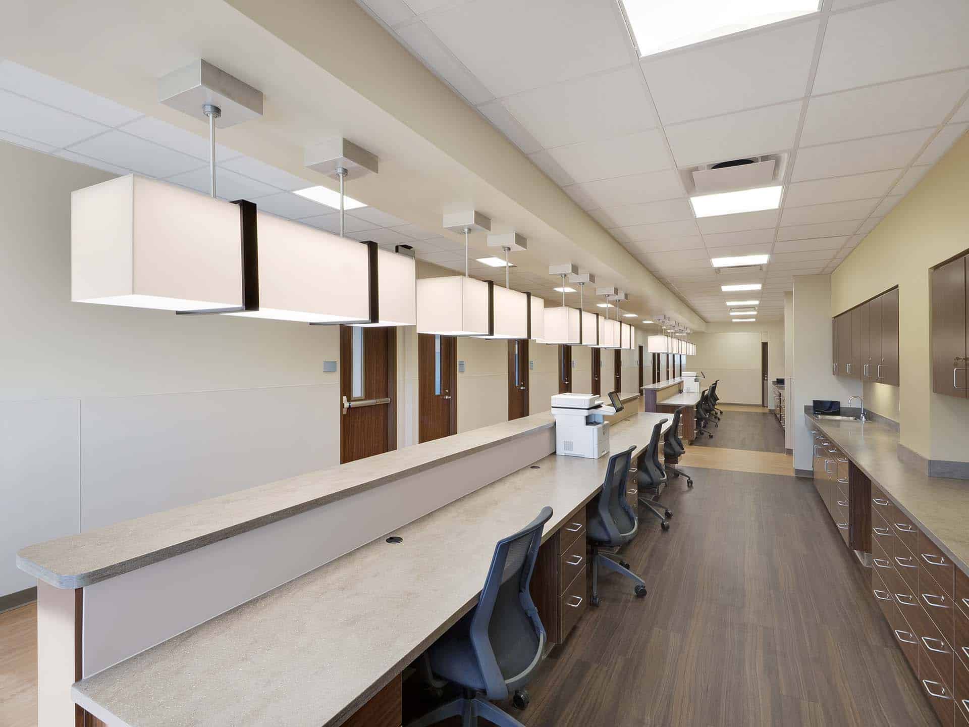 Rows of chairs and cabinets under counters and doors down a hallway