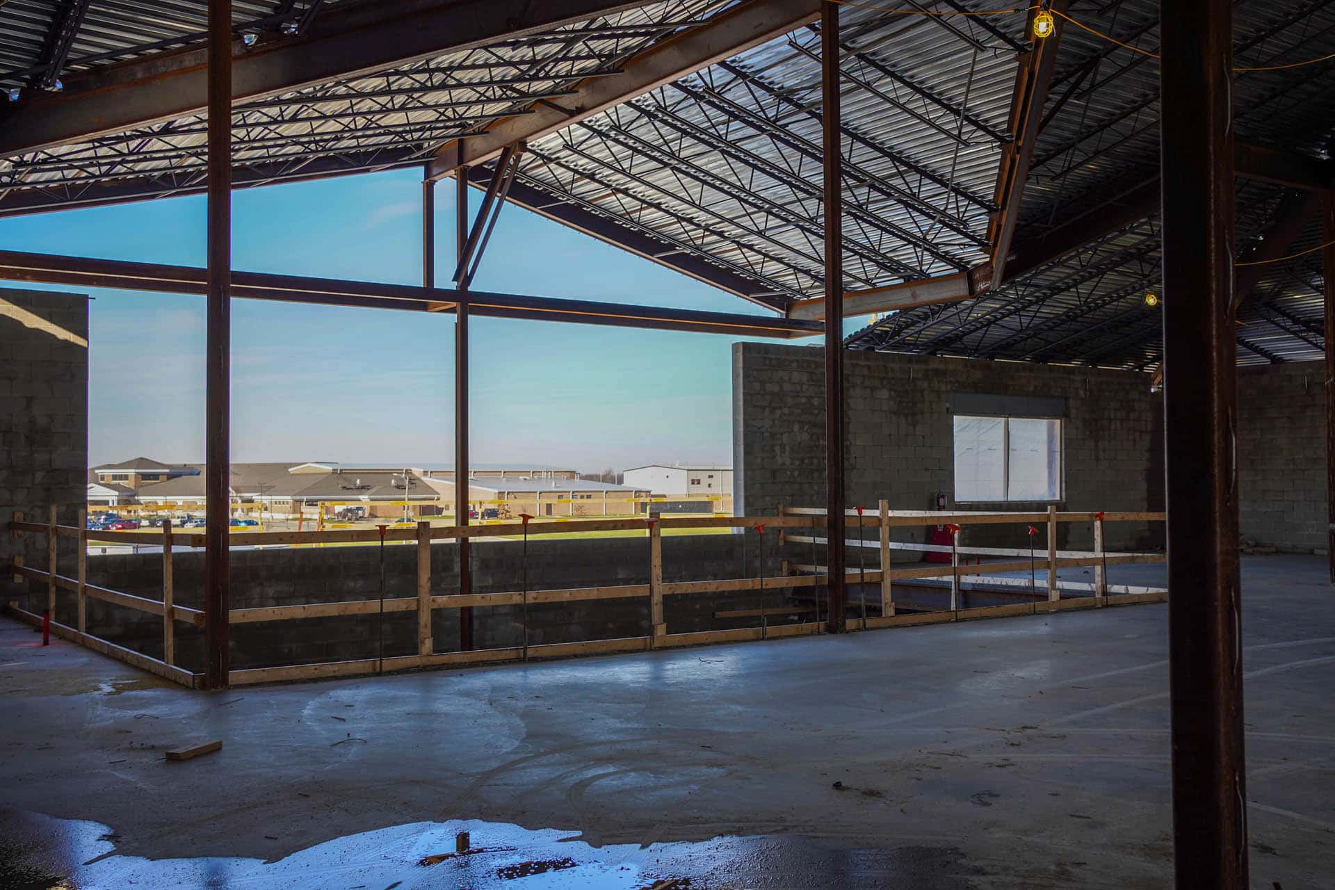 Metal roof and cement floors with temporary safety railing in building under construction