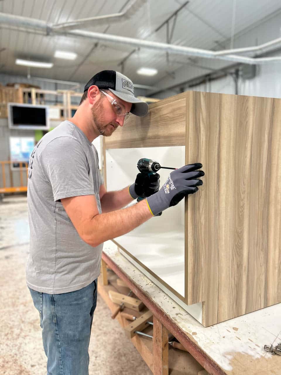 Man drilling in wood cabinet