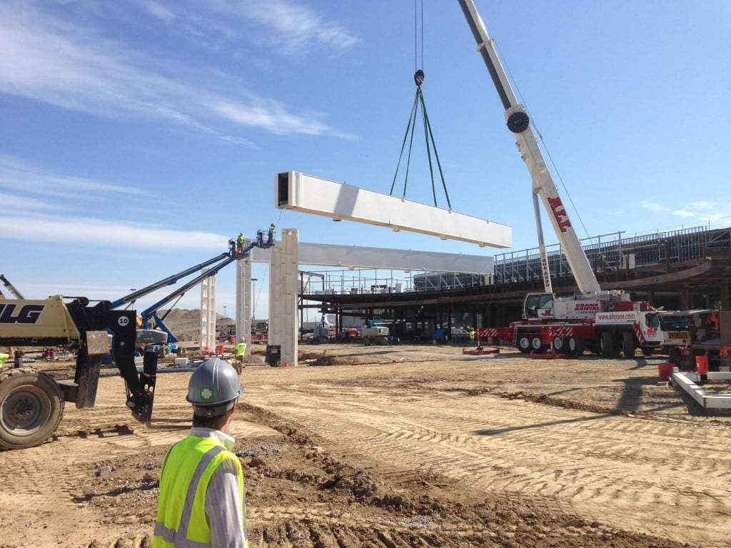 Steel beam being lowered with a boom crane