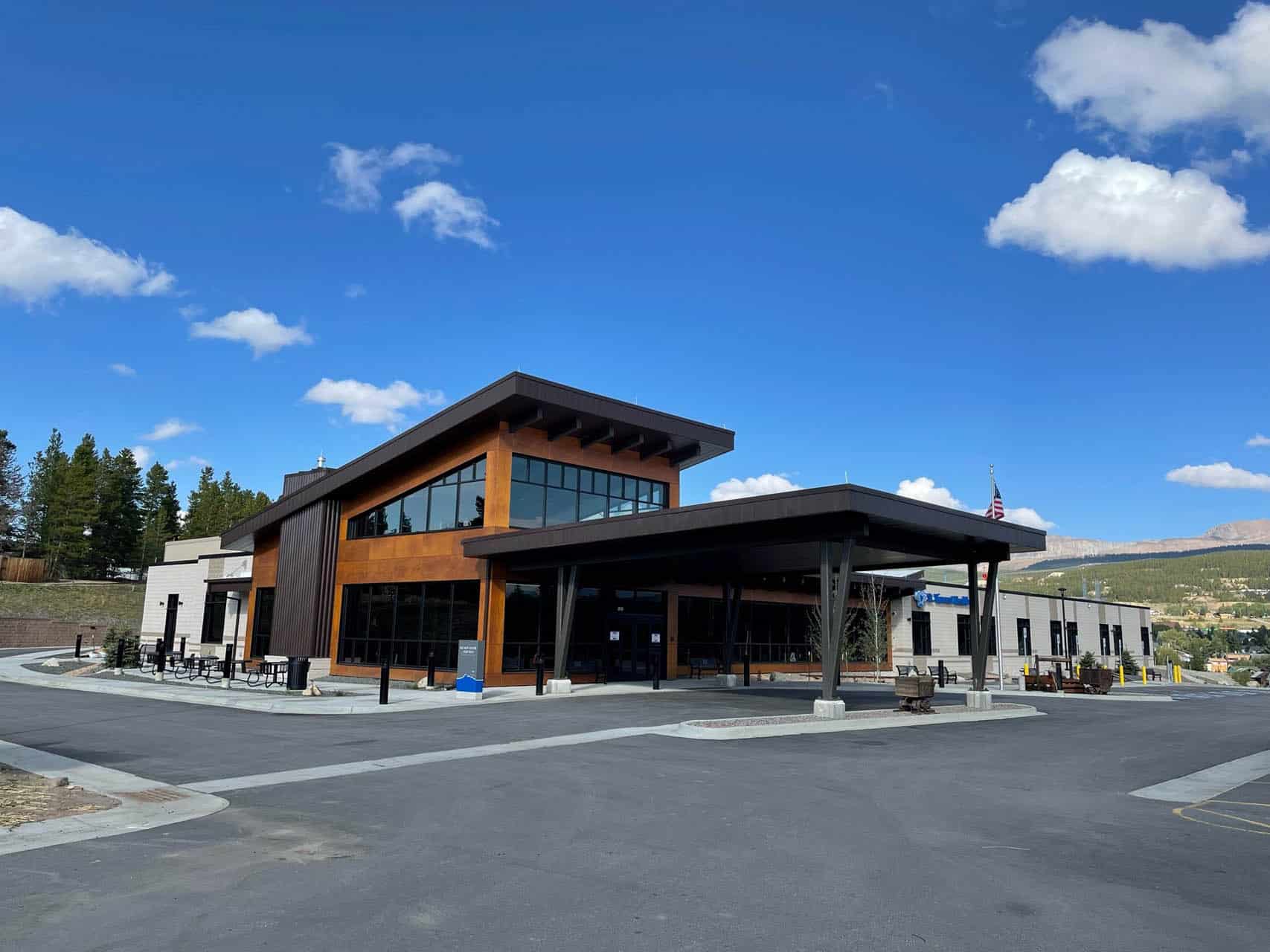 Wood paneled one story building with car drop off area