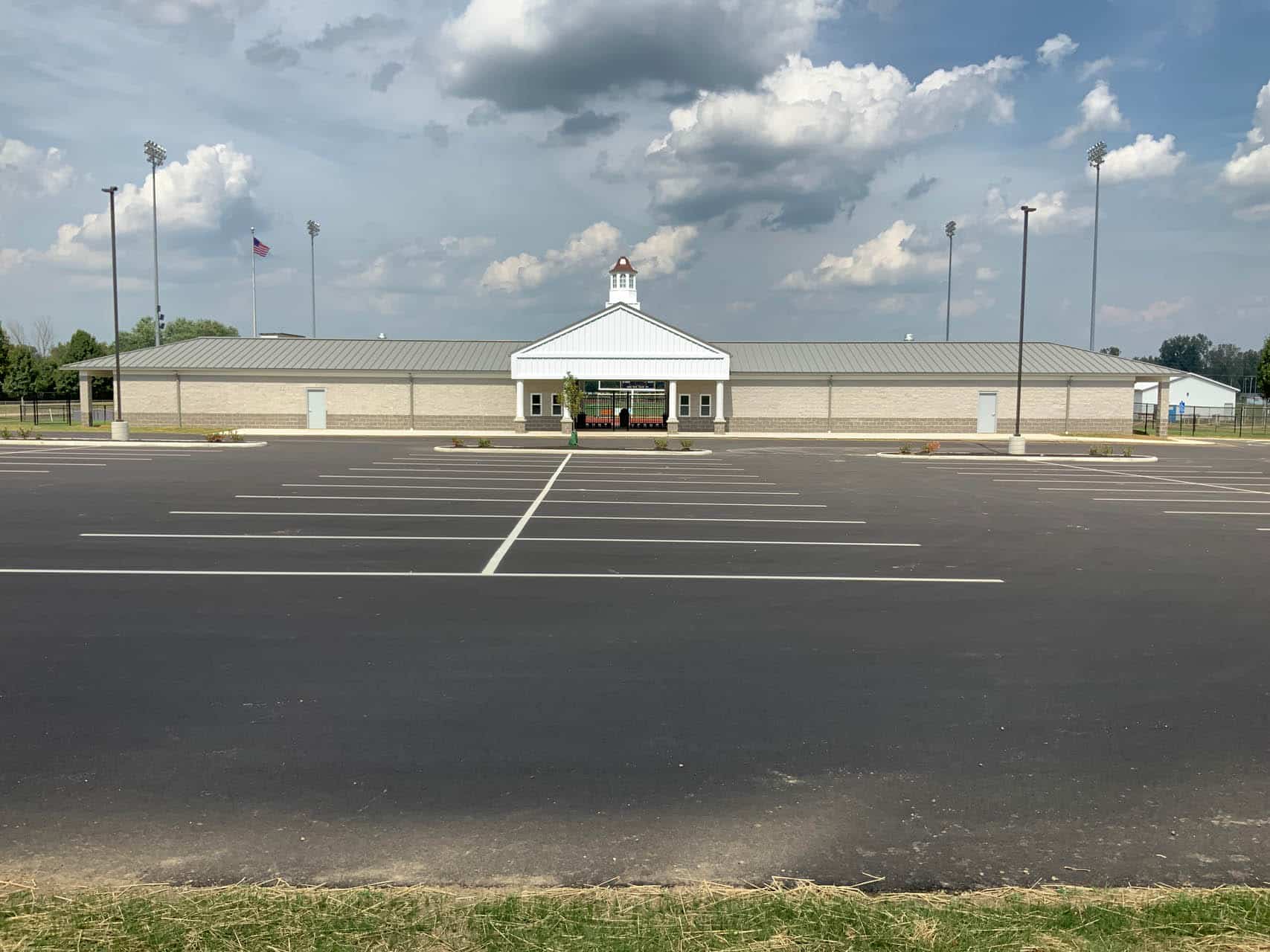 Single-story school building with an empty parking lot in the foreground.