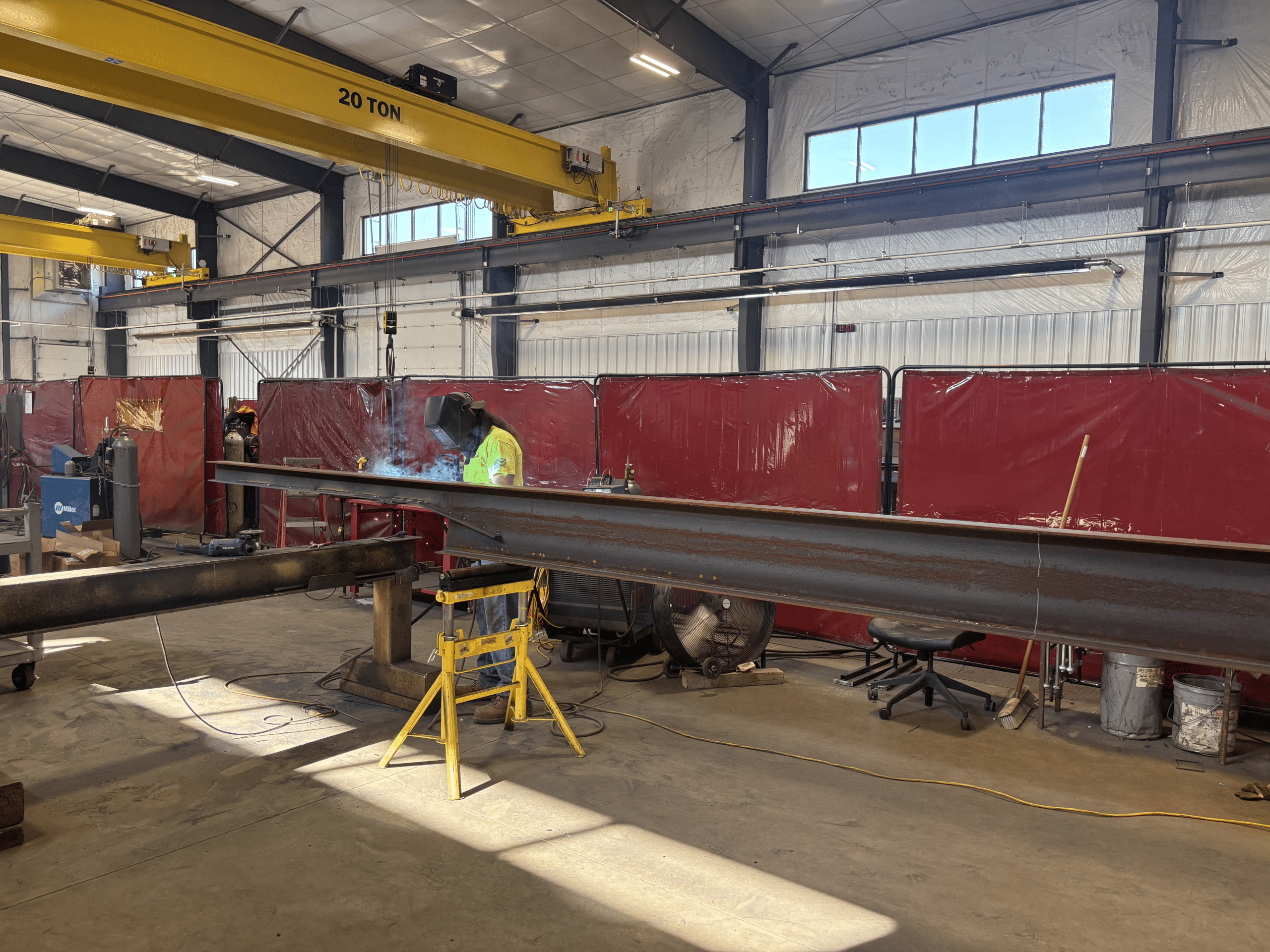 Man in safety gear welding steel in a shop