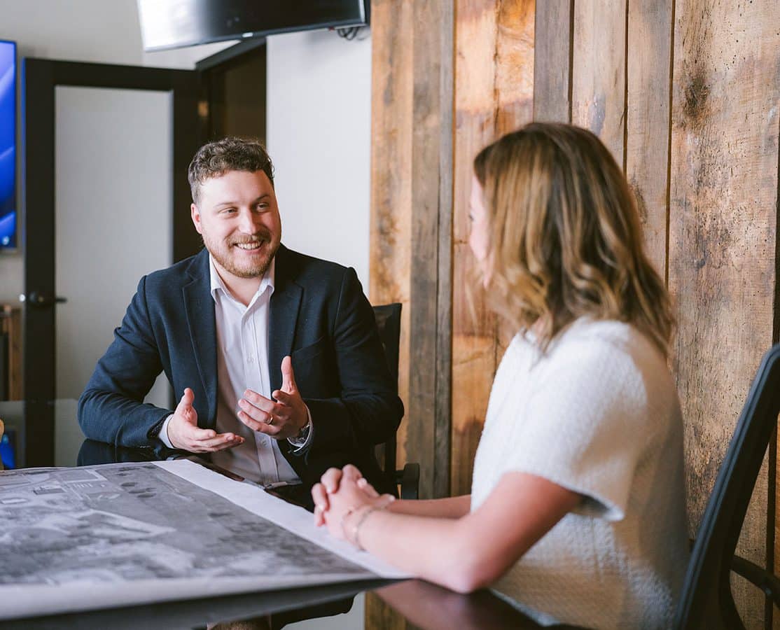 Two colleagues having a conversation at a conference table.